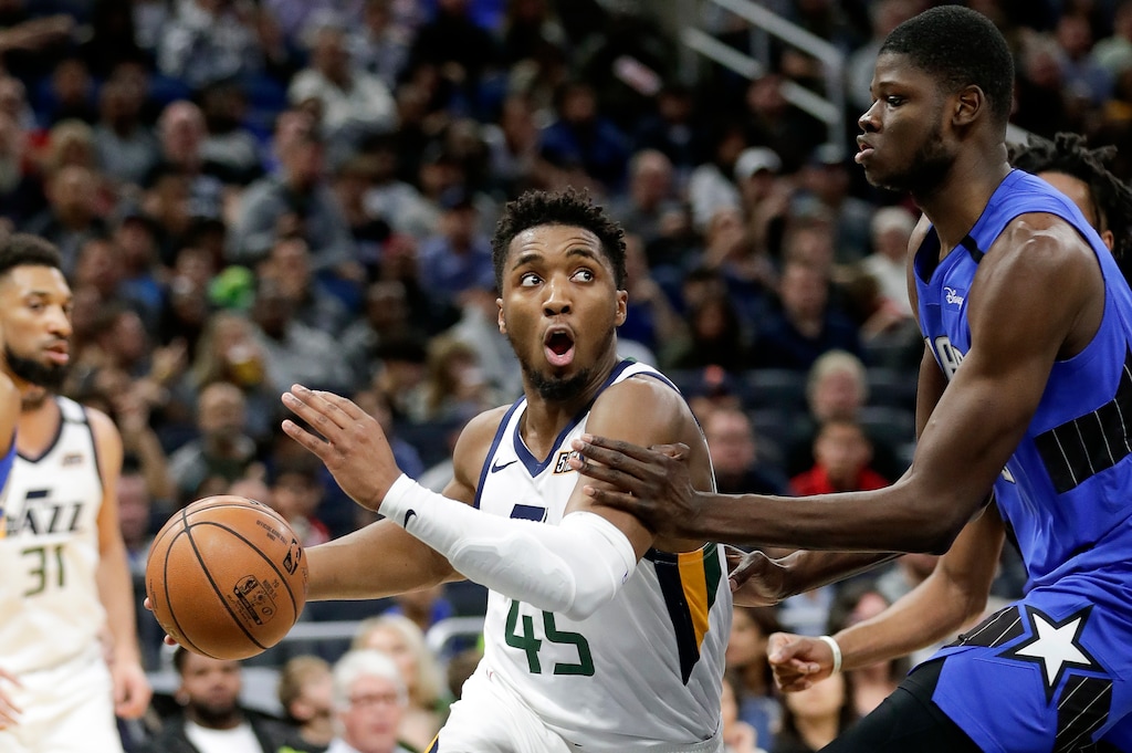Utah Jazz guard Donovan Mitchell (45) drives around Orlando Magic center Mo Bamba during the second half of an NBA basketball game, Saturday, Jan. 4, 2020, in Orlando, Fla. (AP Photo/John Raoux)