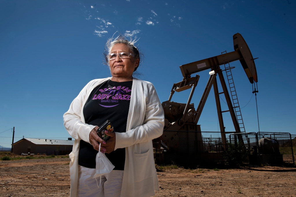 (Leah Hogsten  |  The Salt Lake Tribune) "People say open the doors, open the windows and get some fresh air," said Marilyn Holly, 66. "We cannot do that." Holly, a Navajo Nation Red Mesa Chapter vice-president and advocate for clean air, water and soil poses in front of an Elk Petroleum oil pump jack not far from her home in Montezuma Creek, June 24, 2020. "We live with all these [oil] spills and all the stench, year after year."