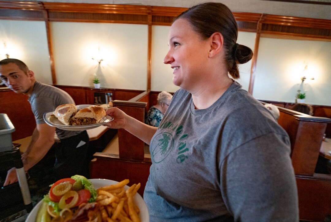 (Francisco Kjolseth | The Salt Lake Tribune) Cori Jeppsen serves up an order of comfort food at Idle Isle Cafe in Brigham City, which is turning 100 this month as seen during a recent lunch rush on Friday, May 14, 2021. In addition to hosting celebrities the likes of John Wayne and Charlie Chapman, locals have brought their kids and grandkids in over the years for the same home cooking and cheerful atmosphere.