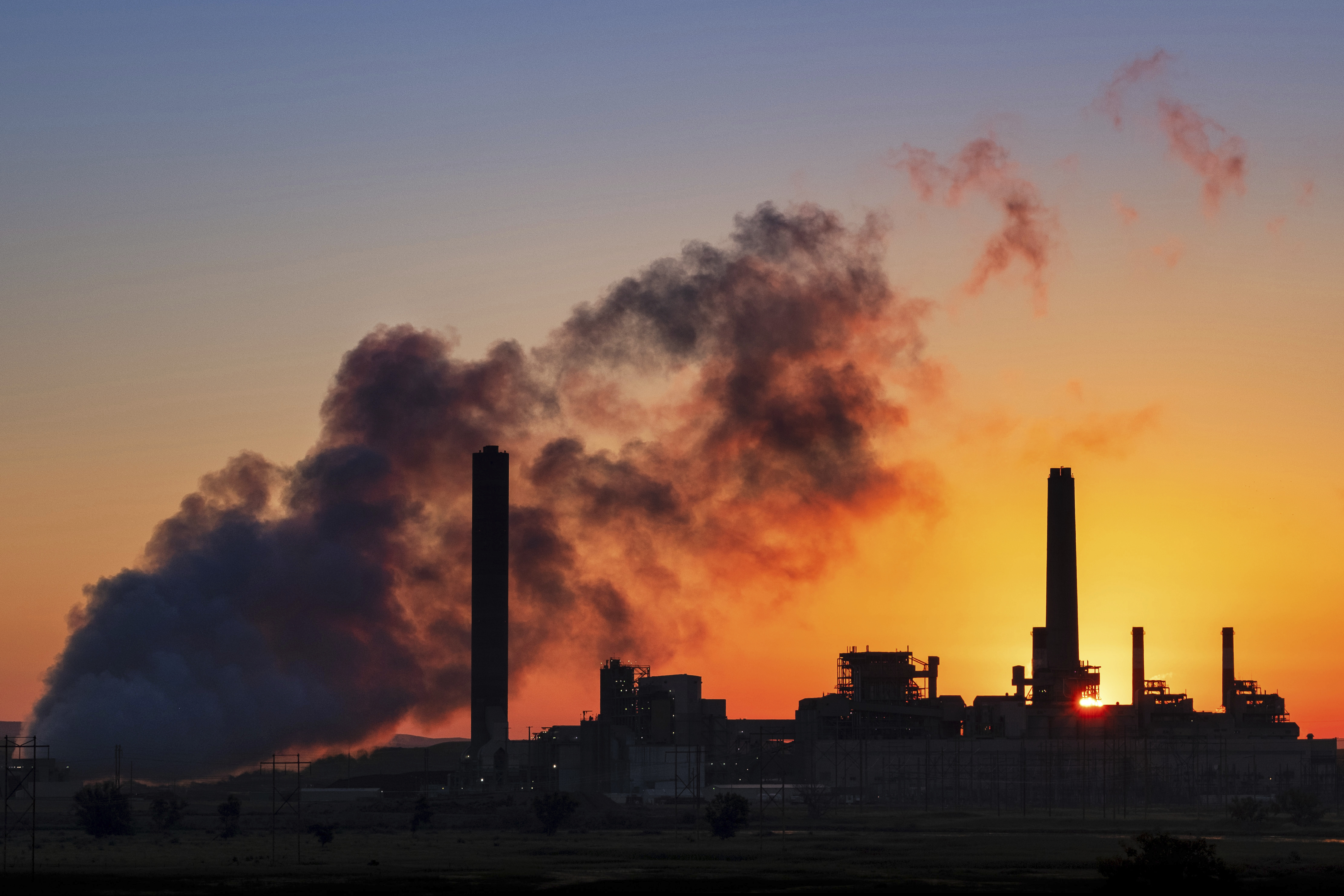 (J. David Ake | AP file photo)  The Dave Johnson coal-fired power plant is silhouetted against the morning sun in Glenrock, Wyo., on July 27, 2018. The Trump administration is proposing easing more Obama-era protections on contaminants from coal-fired power plants. Environmental Protection Agency administrator Andrew Wheeler signed a proposal Monday overhauling a 2015 rule on release of contaminated wastewater from power plants.  The EPA says the change will save $175 million annually in compliance costs.