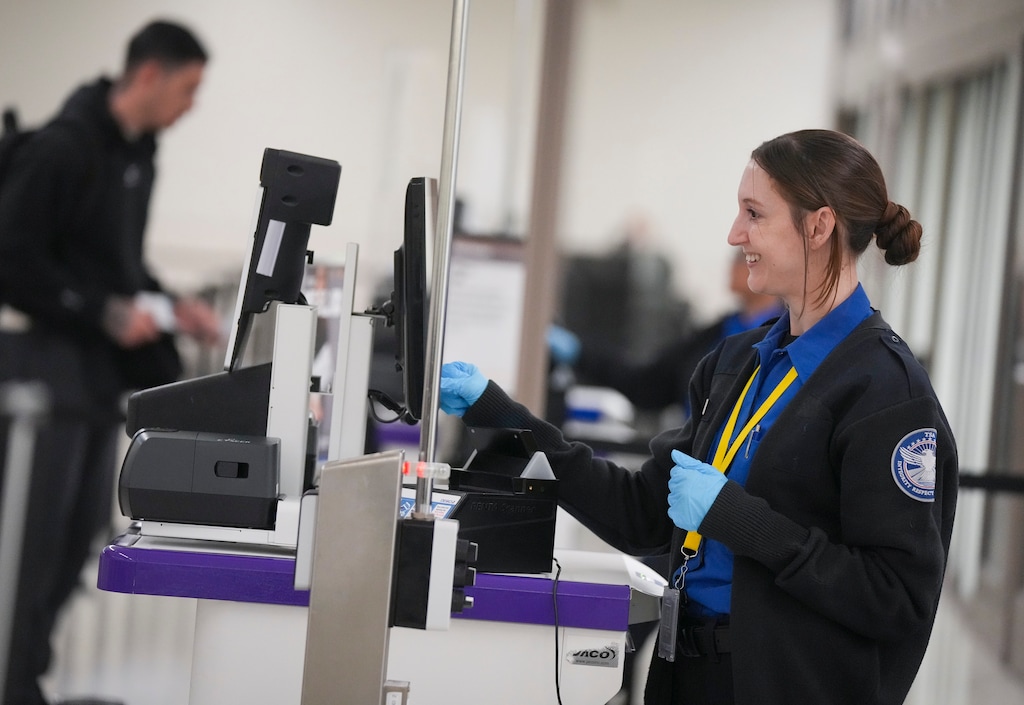 (Bethany Baker  |  The Salt Lake Tribune) A TSA agent assists a traveler at the Salt Lake City International Airport in Salt Lake City during the government shutdown in October of 2025.
