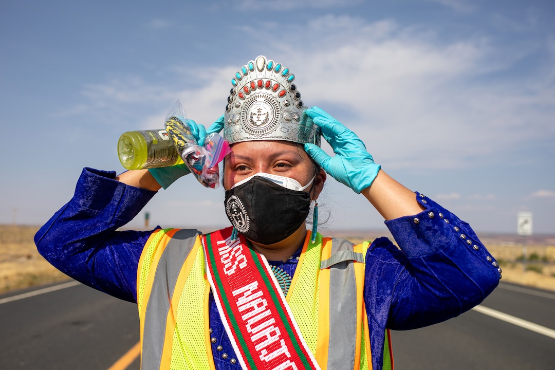 (Sharon Chischilly | The New York Times) Shaandiin Parrish, Miss Navajo Nation, hands out homemade masks, hand sanitizer, and information pamphlets at a checkpoint in Chinle, Ariz., on Aug. 20, 2020.  Native American communities have consistently had higher positivity rates for coronavirus than the general population.