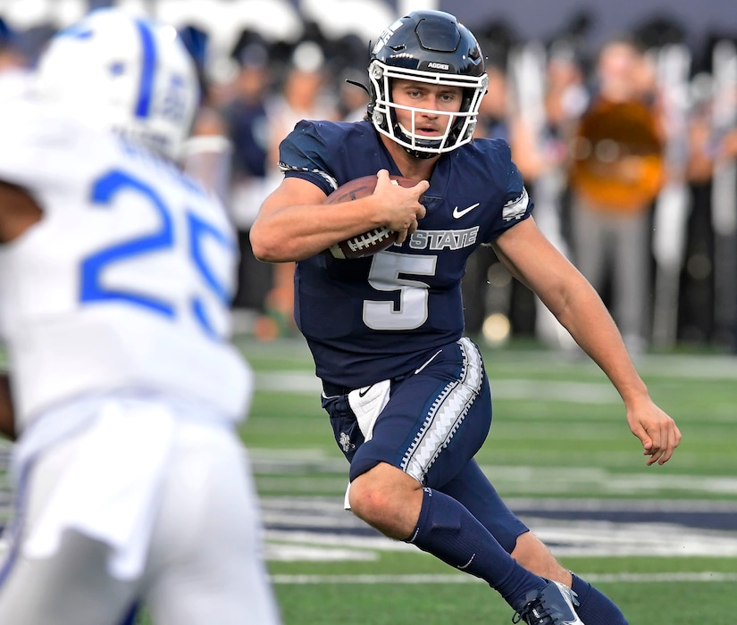 (Eli Lucero | The Herald Journal via AP) Utah State quarterback Cooper Legas (5) runs down the field as Air Force defensive back Jamari Bellamy (25) defends during the first half of an NCAA college football game Saturday, Oct. 8, 2022, in Logan.