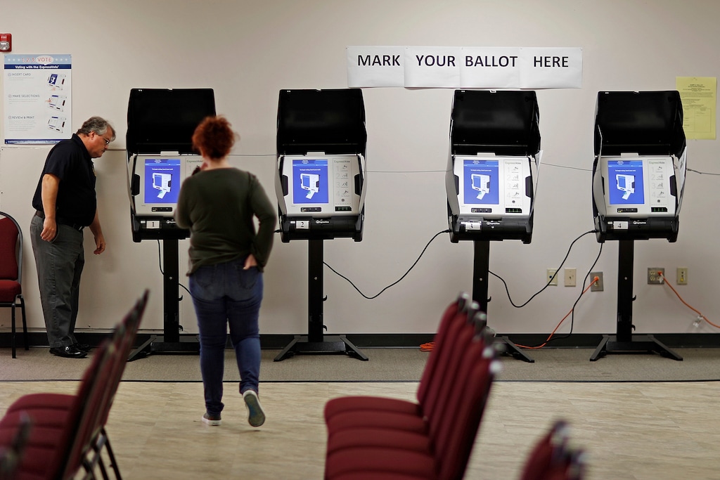 FILE - In this Thursday, Oct. 19, 2017, file photo, Kelly Monroe, investigator with the Georgia Secretary of State office, left, takes a look at a new voting machine that produces a paper record being tested at a polling site in Conyers, Ga. States have quickly tapped into $380 million from the federal government to help them shore up their election systems. A report released Tuesday, Aug. 21, 2018, by the U.S. Election Assistance Commission says the largest chunk will be used to improve cybersecurity in 41 states and territories. More than a quarter of the money will go to buy new voting equipment. (AP Photo/David Goldman, File)