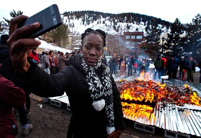 (Rick Egan  |  The Salt Lake Tribune)      Kim Walker from St Elizabeth, Jamaica, takes a selfie infront of the Sundance bonfire, during a community gathering on Swede Alley, in Park City, Thursday, Jan. 30, 2020.