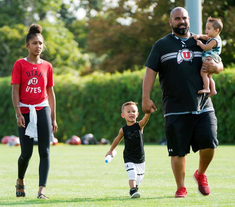 (Rick Egan  |  The Salt Lake Tribune)    Utah defensive line coach Lewis Powell walks with his daughter Vani,12,  L J, 2, as he holds 8-month-old Svaii, after practice, Friday, Aug. 3, 2018.