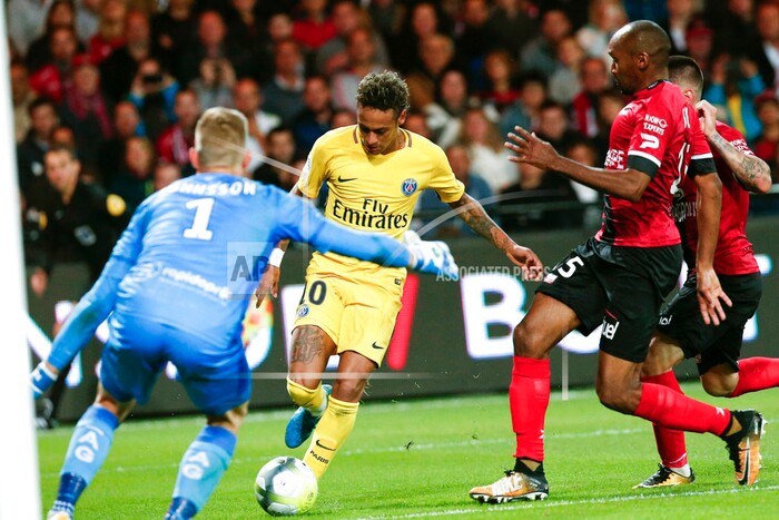 PSG's Neymar, center, tries to score past Guingamp goalkeeper Karl-Johan Johnsson, left, during the French League One soccer match between Guingamp and PSG at the Roudourou stadium in Guingamp, western France, Sunday, Aug. 13, 2017. Neymar makes his long-awaited debut with Paris Saint-Germain on Sunday in the small Brittany town of Guingamp. (AP Photo/Kamil Zihnioglu)