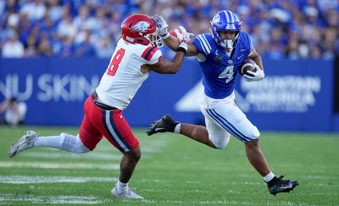 (Francisco Kjolseth | The Salt Lake Tribune) BYU Cougars running back Lj Martin (4) keeps Utah Tech Trailblazers defensive back RJ Jones II (8) at arms length during the first half of an NCAA college football game against Utah Tech, Saturday, Sept. 5, 2026, at LaVell Edwards Stadium in Provo.