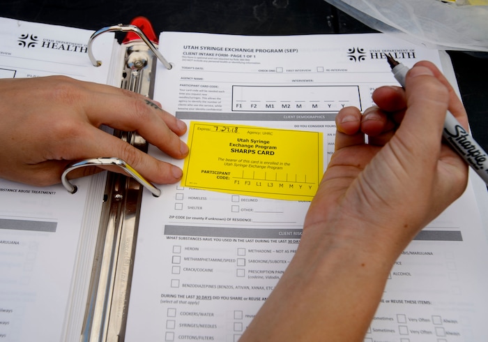 (Steve Griffin  |  The Salt Lake Tribune)  Members from the Utah Harm Reduction Coalition fill out cards for users as they exchange needles on 500 west between 200 south and 300 south in Salt Lake City Thursday July 27, 2017. The state's increased attention to the Rio Grande neighborhood comes as Utah's leading needle exchange provider is under fire for handing out many times more needles than it collects. Mindy Vincent, founder of the coalition, says the goal was never to break even, and that optics aside, needle exchange is proven to reduce the spread of disease among IV drug users.