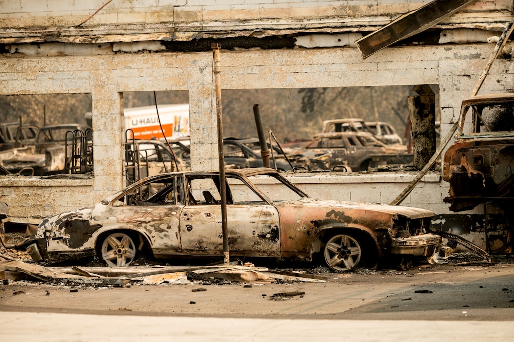 (Noah Berger | AP file photo) Scorched vehicles rest at an auto shop destroyed by the Almeda Fire in Talent, Ore., on Wednesday, Sept. 16, 2020.