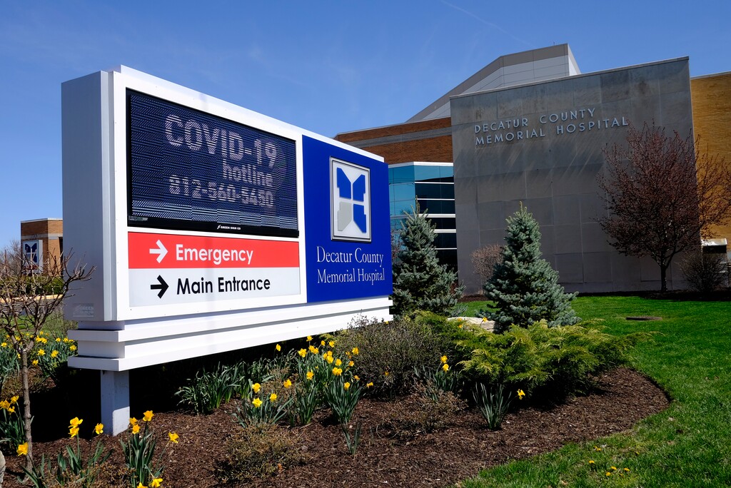 (Darron Cummings | AP file photo) A COVID-19 hot line number is posted outside of Decatur County Memorial Hospital, Thursday, April 2, 2020, in Greensburg, Ind. Three southeast Indiana counties have among the highest per-capita coronavirus infection rates in the country.