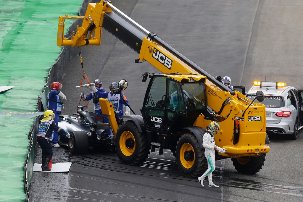 Mercedes driver Lewis Hamilton, of Britain, right, walks away from his car after crashing during the qualifying session for the Brazilian Formula One Grand Prix at the Interlagos race track in Sao Paulo, Brazil, Saturday, Nov. 11, 2017. (AP Photo/Nelson Antoine)