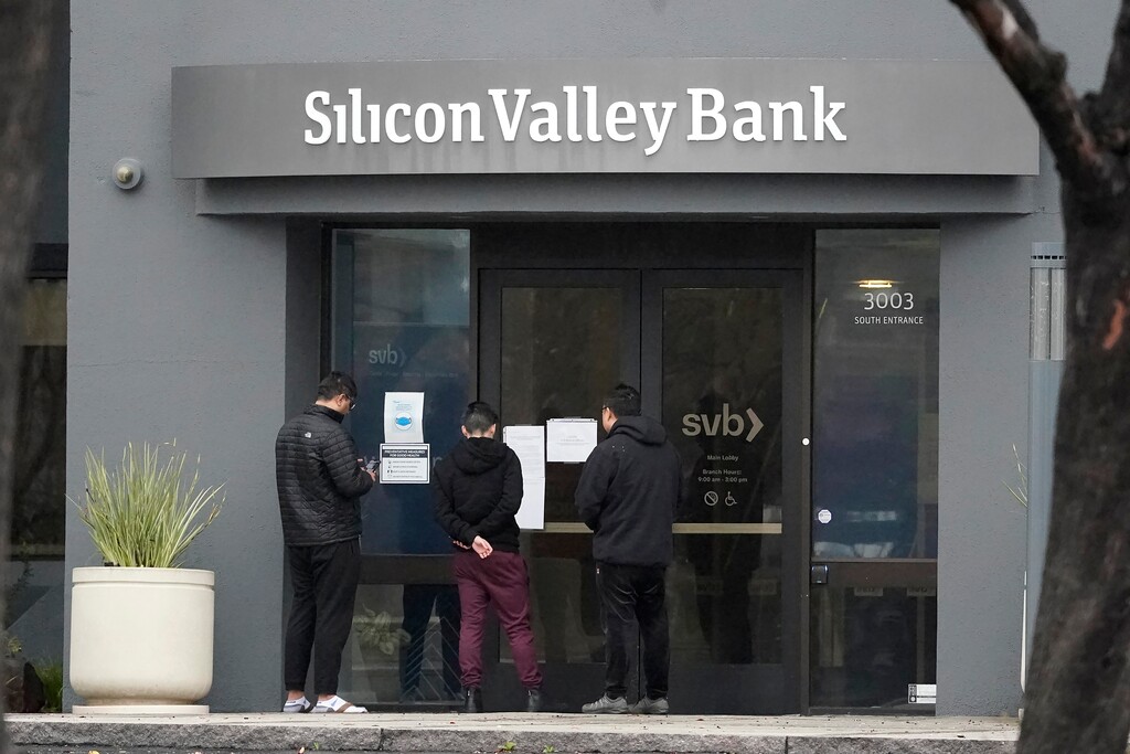 (Jeff Chiu | AP Photo) People look at signs posted outside of an entrance to Silicon Valley Bank in Santa Clara, Calif., Friday, March 10, 2023. The Federal Deposit Insurance Corporation is seizing the assets of Silicon Valley Bank, marking the largest bank failure since Washington Mutual during the height of the 2008 financial crisis. The FDIC ordered the closure of Silicon Valley Bank and immediately took position of all deposits at the bank Friday.