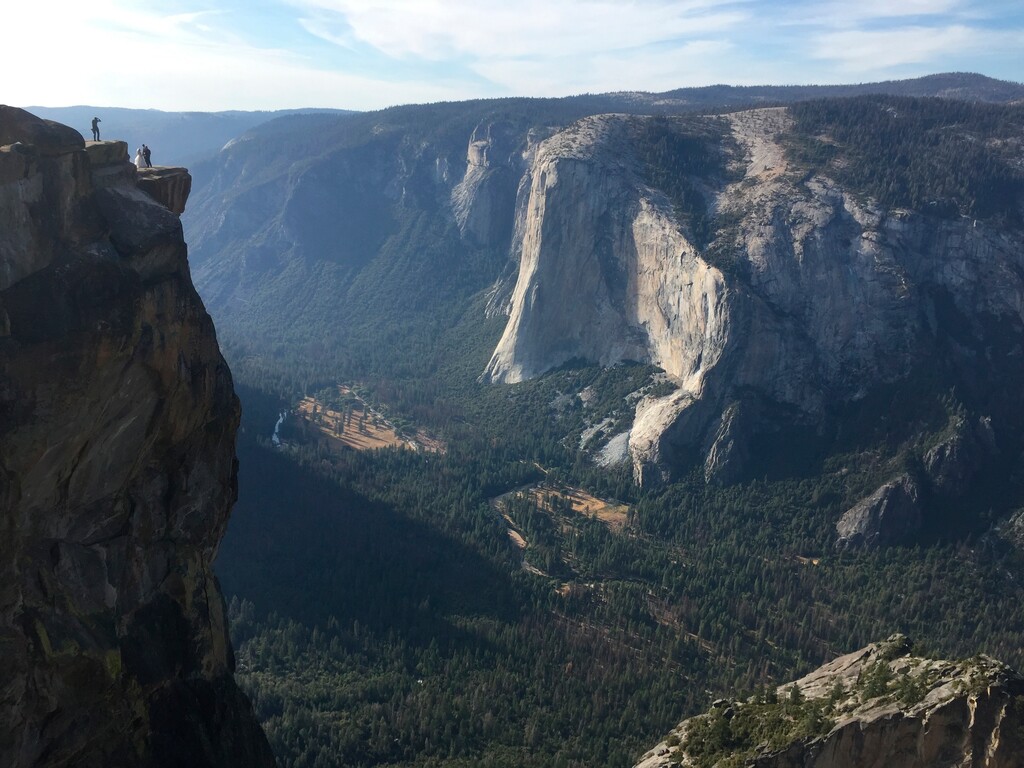 FILE - In this Sept. 27, 2018 file photo a wedding couple are seen being photographed at Taft Point in California's Yosemite National Park. A Yosemite National Park official says two visitors have died in a fall from the popular overlook. Park rangers are trying to recover the bodies of a man and a woman Thursday, Oct.25, 2018. He didn't say when the couple fell from Taft Point, which is at an elevation of 7,500 feet. Gediman says the deaths are being investigated and offered no other information. (AP Photo/Amanda Lee Myers,File)