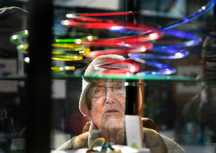 (Scott Sommerdorf   |  The Salt Lake Tribune)   Ann O'Connell looks at the piece entitled "Springtime" by Ruth Ann Garner at the Glass Art Guild of Utah show at Red Butte Garden, Sunday, November 19, 2017. 