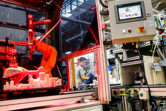 In this Thursday, May 25, 2017 photo, an assembly line laborer works alongside a collaborative robot, left, on a chainsaw production line at the Stihl Inc. production plant in Virginia Beach, Va. Despite efficiency increases and lessening the need for manual laborers, companies require workers who can program, oversee, operate, and maintain the automation. A report by Deloitte Consulting and the American Manufacturing Institute estimates 2 million such jobs will need to be filled over the next decade. (AP Photo/John Minchillo)