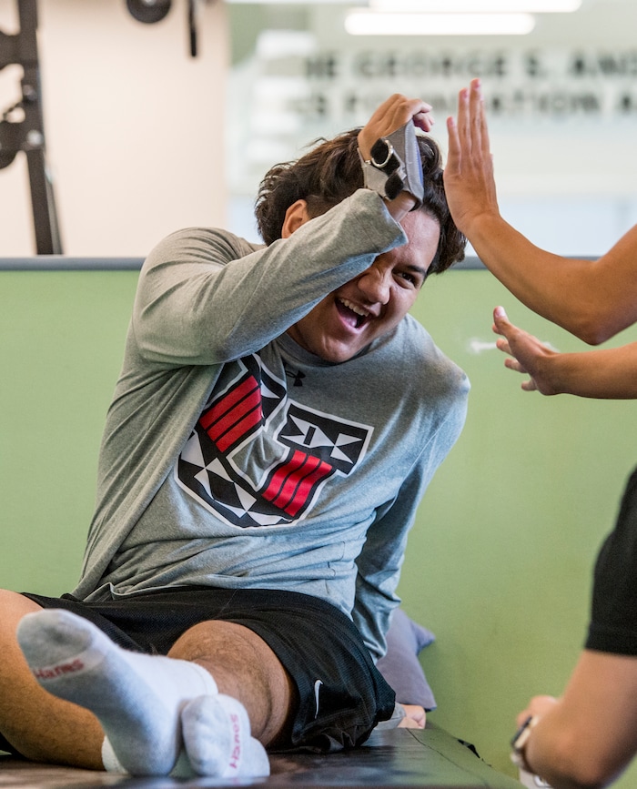 (Leah Hogsten  |  The Salt Lake Tribune) Stak high-fives a therapist at Neuroworx after reaching a new milestone in his workout routine, June 21, 2019. Audrick “Stak” Afatasi is fighting to regain movement in his lower body after being paralyzed at a trampoline park on March 15, 2019.