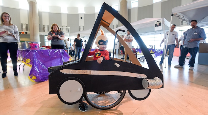 (Francisco Kjolseth  |  The Salt Lake Tribune)  Cooper Baskett, 3, assumes the role of Jack-Jack from the movie "The Incredibles" as an army of volunteers and staff at Shriners Hospital for Children in Salt Lake finish his Incredimobile and those of another 27 patients in wheelchairs for Halloween, Wednesday, Oct. 17, 2018. Cooper, who has skeletal dysplasia, relished the attention, frequently flashing some of his character's signature moves. "This is something he gets to have all his own," exclaimed his mother, Tonya Baskett.