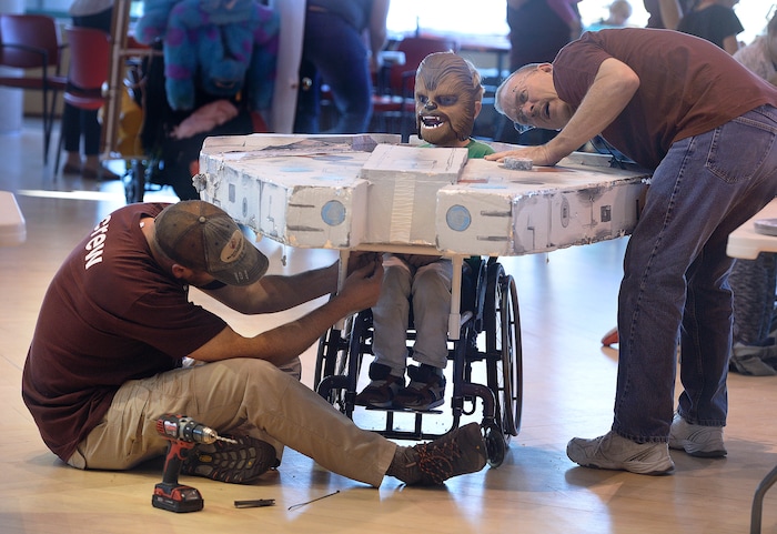 (Scott Sommerdorf | The Salt Lake Tribune)
Matt Lowell, and Lex Anderson, right work on the "Millennium Falcon" addition to Davey Killpack's wheelchair as Shriners Hospitals for Children volunteers transform the wheelchairs of 20 patients for Halloween, Wednesday, October 18, 2017.