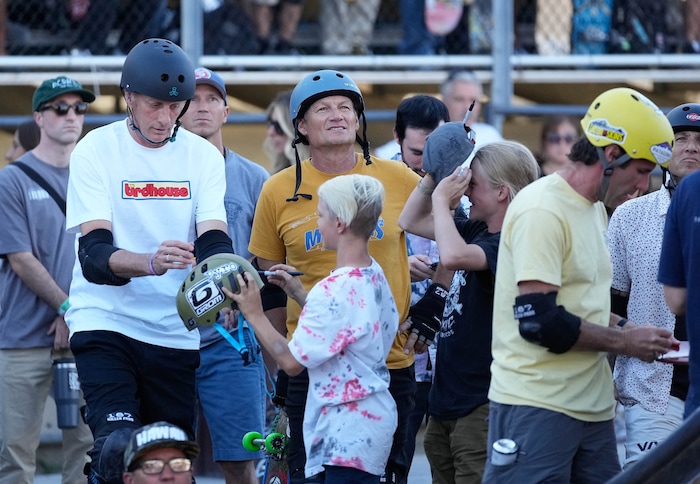 (Francisco Kjolseth | The Salt Lake Tribune) Iconic skateboarder Tony Hawk signs an autograph for a young fan as he returns to the ramp to skate in public for the first, and possibly last, time since breaking his femur in March as he enters the “Legends Demo” at his Tony Hawk Vert Alert big-air skateboarding competition at the Utah Sate Fairpark on Friday, Aug. 26, 2022. 