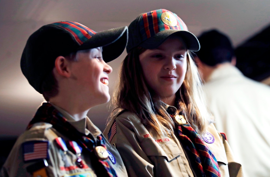 (AP Photo/Charles Krupa) In a Thursday, March 1, 2018, photo, Ian Weir, left, smiles as he stands with his twin sister, Tatum, after a Cub Scout meeting in Madbury, N.H. Fifteen communities in New Hampshire are part of an "early adopter" program to allow girls to become Cub Scouts and eventually Boy Scouts. The twins already are planning to become the first set of girl-boy siblings to become Eagle Scouts.