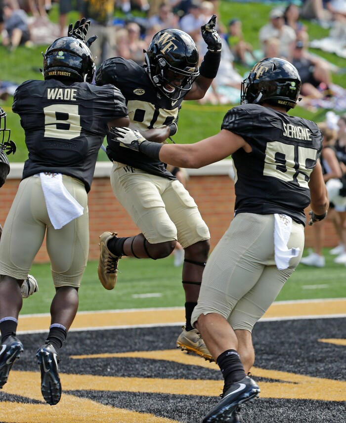 Wake Forest's Greg Dortch (89) celebrates his touchdown catch against Utah State with Cam Serigne (85) and Chuck Wade (9) in the first half of an NCAA college football game in Winston-Salem, N.C., Saturday, Sept. 16, 2017. (AP Photo/Chuck Burton)