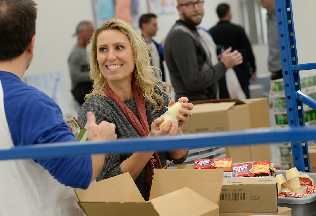 (Francisco Kjolseth  |  The Salt Lake Tribune)  Michelle Benedict, who founded Kids Next Door and is now the engagement manager for USANA Kids Eat, pitches in restocking the line as USANA staff volunteer their time assembling food bags for at-risk youth at the newly-renovated packing and storage facility next to the headquarters of the Salt Lake City company on Wed. Dec. 11, 2019. The USANA Foundation has acquired two local charities, Kids Next Door and KidsEat!, that provides hundreds of food bags every week for the kids for the weekends and during long school breaks.