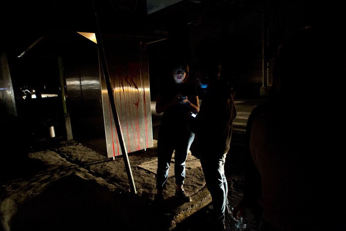 People who evacuated from bars check their phones in the street in La Roma neighborhood of Mexico City, after an earthquake shook buildings forcefully and knocked out power in the area, just before midnight on Thursday, Sept. 7, 2017. A massive earthquake hit off the coast of southern Mexico late Thursday night, causing buildings to sway violently and people to flee into o the streets in panic as far away as the capital city. (AP Photo/Rebecca Blackwell)