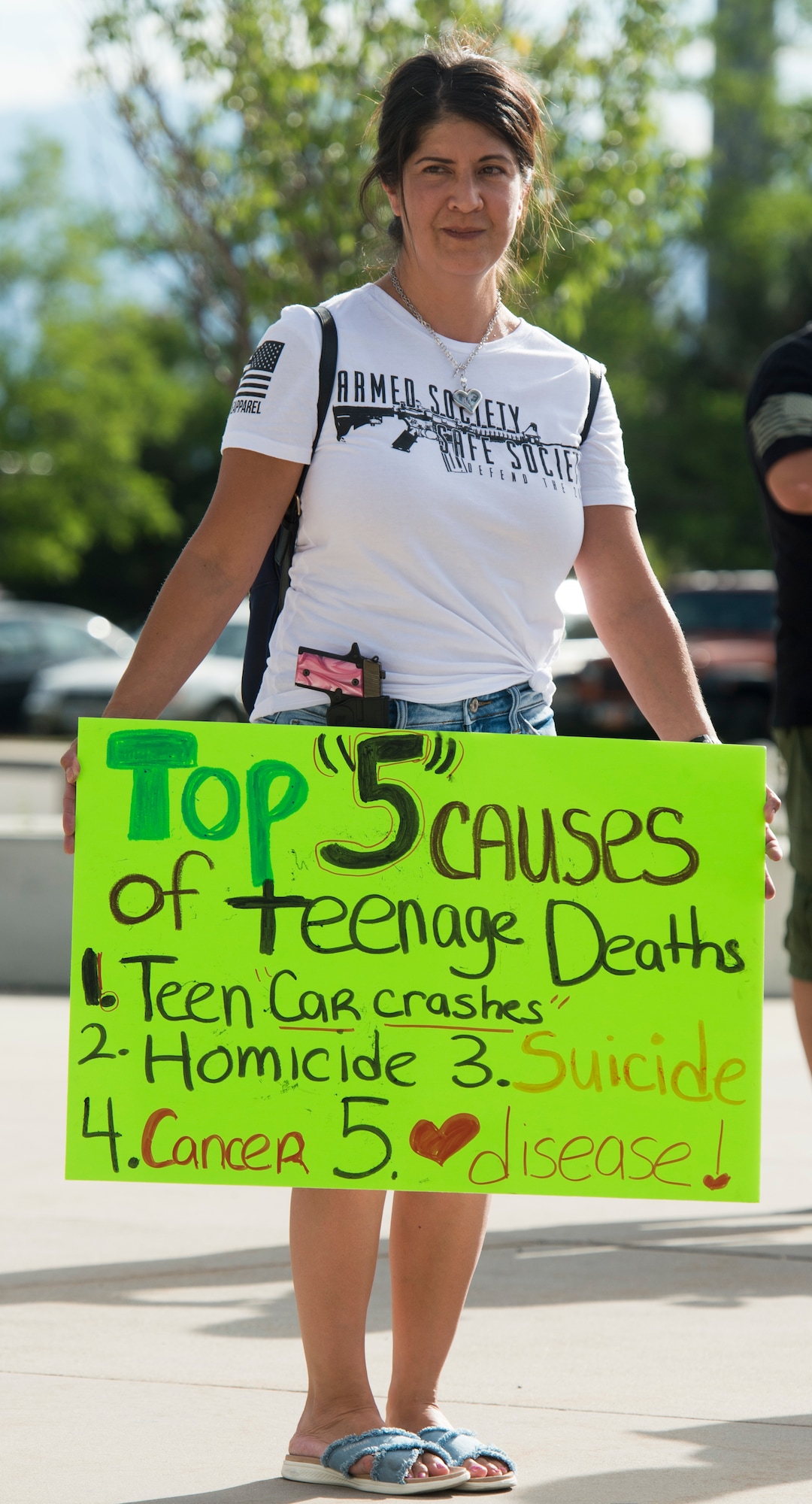 (Rick Egan  |  The Salt Lake Tribune)     Michelle North, from South Jordan, displays her sign and her weapon,  before a town hall meeting in Sandy, where survivors from the Florida school shooting held a forum with Utah students involved with the March for Our Lives movement, Saturday, July 14, 2018.