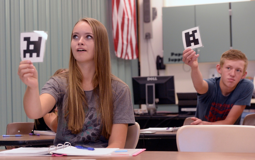 (Al Hartmann  |  The Salt Lake Tribune)  Park Valley School students Laney Jensen and Derek Kunzler in their 9th-10th grade class  history class hold their card towards camera during via interactive video conference.