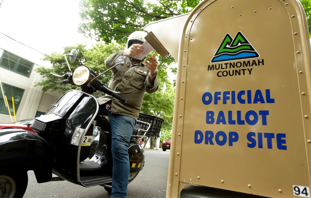 (Don Ryan | AP file photo)  A voter drops off his ballot on the day of Oregon's primary election at a drive-by, drop-off station in Portland, Ore., on May 15, 2018.