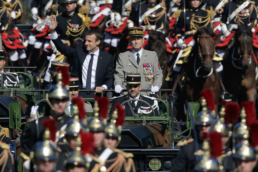 FILE - In this July 14, 2017 file photo, French President Emmanuel Macron, left, and Chief of the Defense Staff Gen. Pierre de Villiers, right, drive down the Champs Elysees avenue during Bastille Day parade in Paris. Macron's government is unveiling a bill to boost military spending, notably amid demands by NATO and President Donald Trump for European countries to pitch in more for their own defense. (AP/Photo/Markus Schreiber, File)