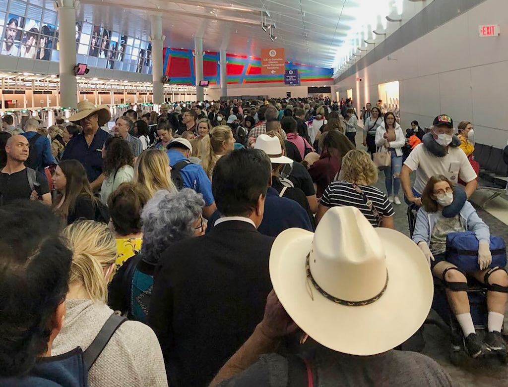 (Austin Boschen via AP) In this photo provided by Austin Boschen, people wait in line to go through the customs at Dallas Fort Worth International Airport in Grapevine, Texas, Saturday, March 14, 2020. International travelers reported long lines at the customs at the airport Saturday as staff took extra precautions to guard against the new coronavirus, The Dallas Morning News reports. Boschen said it took him at least 4 hours to go through the customs.