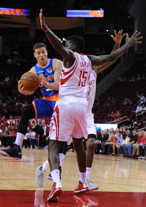 The Shanghai Sharks Jimmer Fredette, left, drives by the Houston Rockets Clint Cappella, right, in the first half of an NBA basketball exhibition game Sunday, Oct. 2, 2016, in Houston. (AP Photo/George Bridges)