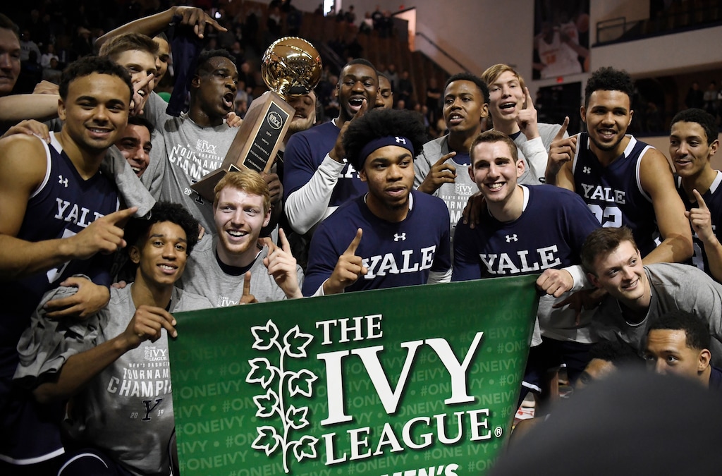 FILE - In this March 17, 2019, file photo, Yale players pose for a photograph with the championship trophy after defeating Harvard in an NCAA college basketball game for the Ivy League championship at Yale University in New Haven, Conn. The Ivy League on Tuesday, March 10, 2020, canceled its men's and women's basketball tournaments because of concerns about the spread of coronavirus. The four-team tournaments were scheduled to be played Friday through Sunday at Lavietes Pavilion in Cambridge. The Ivy League instead will award its automatic NCAA Tournament bids to the regular-season champions, the Princeton women and Yale men. (AP Photo/Jessica Hill, File)