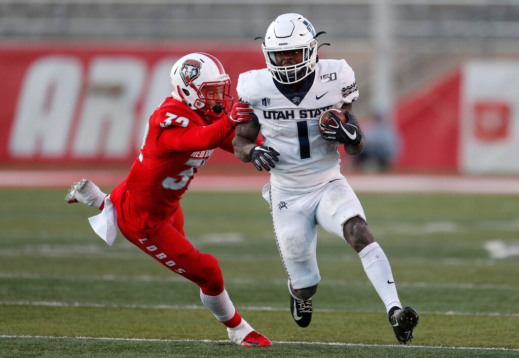 Utah State running back Gerold Bright (1) runs for yardage defended by New Mexico safety Johnny Hernandez (32) during the second half of an NCAA college football game on Saturday, Nov. 30, 2019 in Albuquerque, N.M. (AP Photo/Andres Leighton)