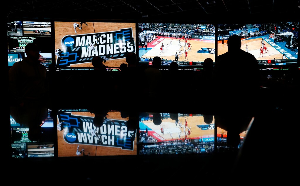 In this March 15, 2018 photo, people watch coverage of the first round of the NCAA college basketball tournament at the Westgate Superbook sports book in Las Vegas. The Supreme Court has struck down a federal law that bars gambling on football, basketball, baseball and other sports in most states, giving states the go-ahead to legalize betting on sports.   (AP Photo/John Locher)