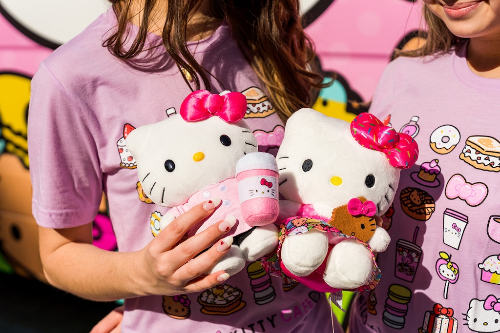 (Sanrio) Fans hold plush toys of Sanrio's Hello Kitty in front of a Hello Kitty Cafe truck. One of the touring trucks is scheduled to land at Murray's Fashion Place Mall on Saturday, May 14, 2022.