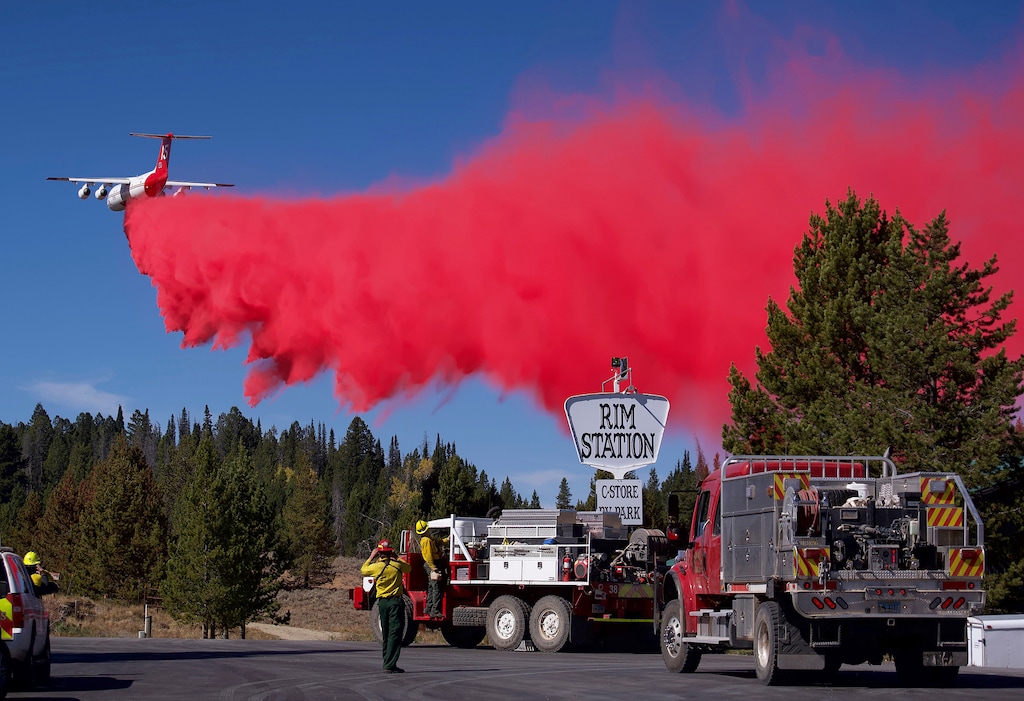 Heavy aircraft drops fire retardant near the Rim Station, a convenience store and RV park between Bondurant and Daniel, Wyo., on Tuesday, Sept. 25, 2018, during efforts to keep the Roosevelt Fire at bay. The area was evacuated Sunday as the fire approached. (Ryan Dorgan/Jackson Hole News & Guide via AP)