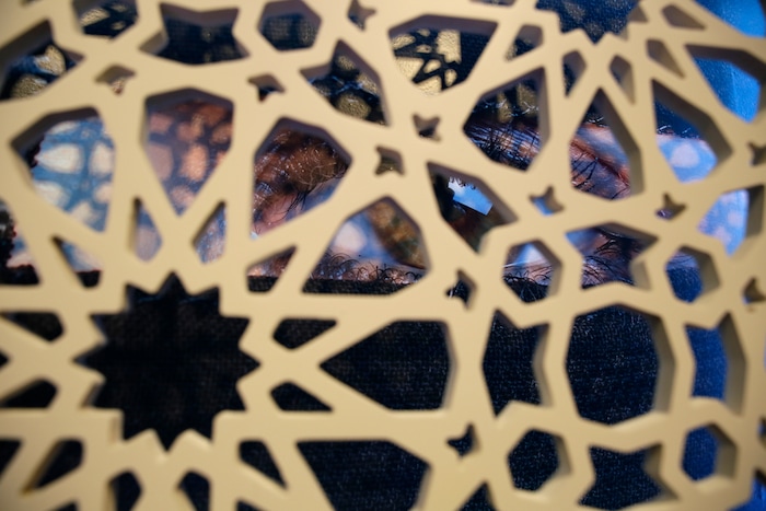 (Eric Risberg  |  AP Photo)  In this photo taken Thursday, Sept. 20, 2018, a photograph of a woman's eye is seen behind a latticework in the exhibit Contemporary Muslim Fashions at the M. H. de Young Memorial Museum in San Francisco. The first major museum exhibition of contemporary Muslim women's fashion reflects designs from around the world that are vibrant and elegant, playful and diverse. The show's creators hope the exhibit will show Muslim women as real people who can choose what they wear rather than as subjects ordered to cover their entire bodies or restricted in what they can wear. The exhibit opens on Saturday.