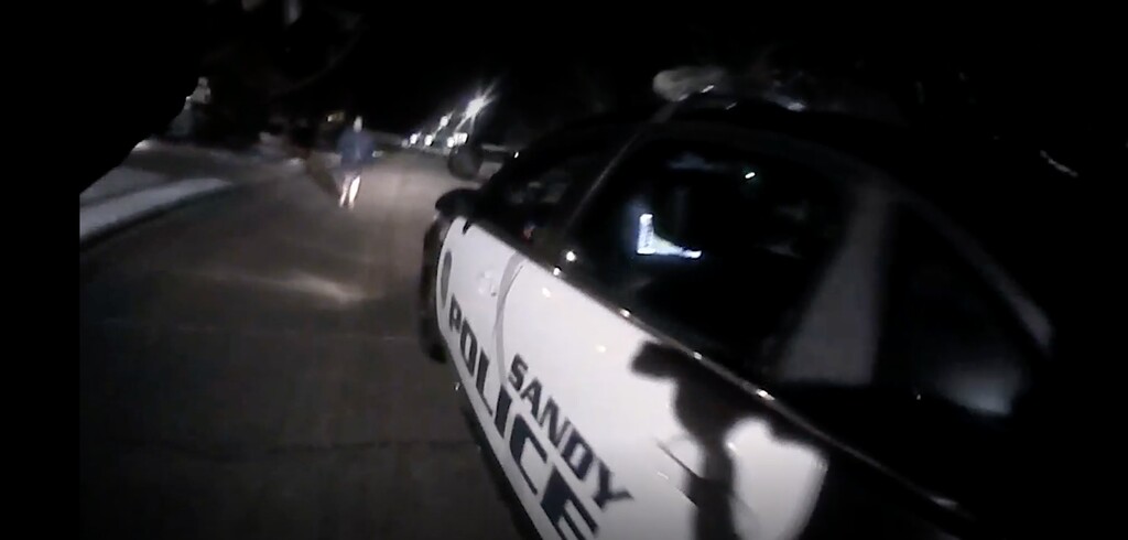 (Sandy Police Department) In this screenshot from police body camera video, a Sandy police officer points his weapon at Dylan Murphy, 33, on March 26, 2023. Murphy later died as a result of his injuries from the shooting.