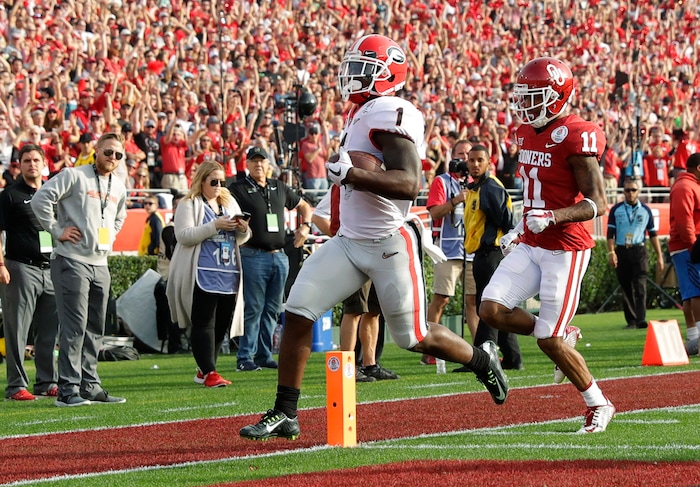 Georgia running back Sony Michel, left, runs past Oklahoma cornerback Parnell Motley, right, to score a touchdown during the first half of the Rose Bowl NCAA college football game Monday, Jan. 1, 2018, in Pasadena, Calif. (AP Photo/Gregory Bull)