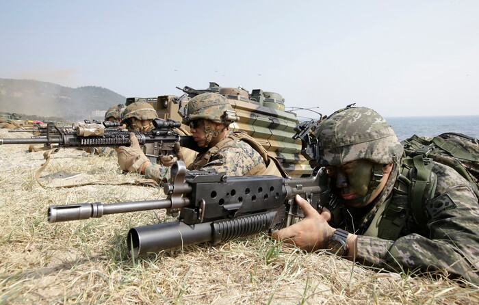 FILE - In this March 30, 2015, file photo, Marines of South Korea, right and the U.S aim their weapons near amphibious assault vehicles during the U.S.-South Korea joint landing military exercises as a part of the annual joint military exercise Foal Eagle between South Korea and the United States in Pohang, South Korea. America’s annual joint military exercises with South Korea always frustrate North Korea. The war games set to begin Monday, Aug. 21, 2017 may hold more potential to provoke than ever, given President Donald Trump’s “fire and fury” threats and Pyongyang’s as-yet-unpursued plan to launch missiles close to Guam. (AP Photo/Lee Jin-man, File)