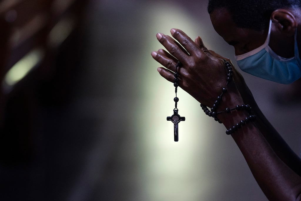 (Leo Correa | AP file photo) With rosary beads wrapped around clasped hands, a man bows in prayer during a Mass at the Metropolitan Cathedral, in Rio de Janeiro, Brazil, Saturday, July 4, 2020.
