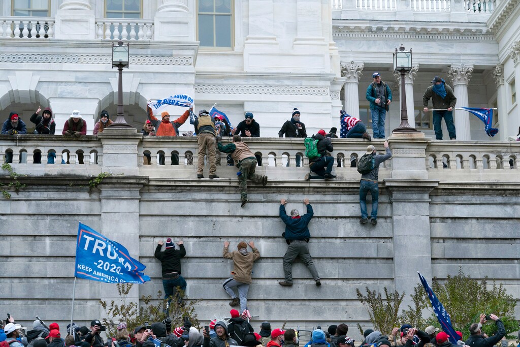 (Jose Luis Magana | The Associated Press)Supporters of President Donald Trump climb the west wall of the U.S. Capitol on Jan. 6, 2021, in Washington. The mob proceeded to breach the Capitol.