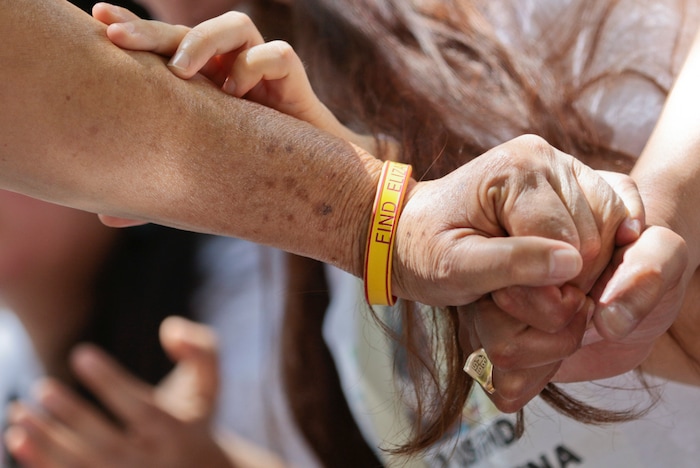 Libertad Edith Salgado-Figueroa and her daughter, Ruth Yolanda Laguna-Salgado, hold hands as they pray together Friday, June 15, 2018, in Hobble Creek Canyon near Provo, Utah, where Elizabeth Elena Laguna-Salgado was found. The remains of the 26-year-old Mexican woman were discovered by a passer-by looking for a camping spot last month. She had been missing since April 16, 2015, when she was last seen walking home from her English language class. (Evan Cobb/The Daily Herald via AP)