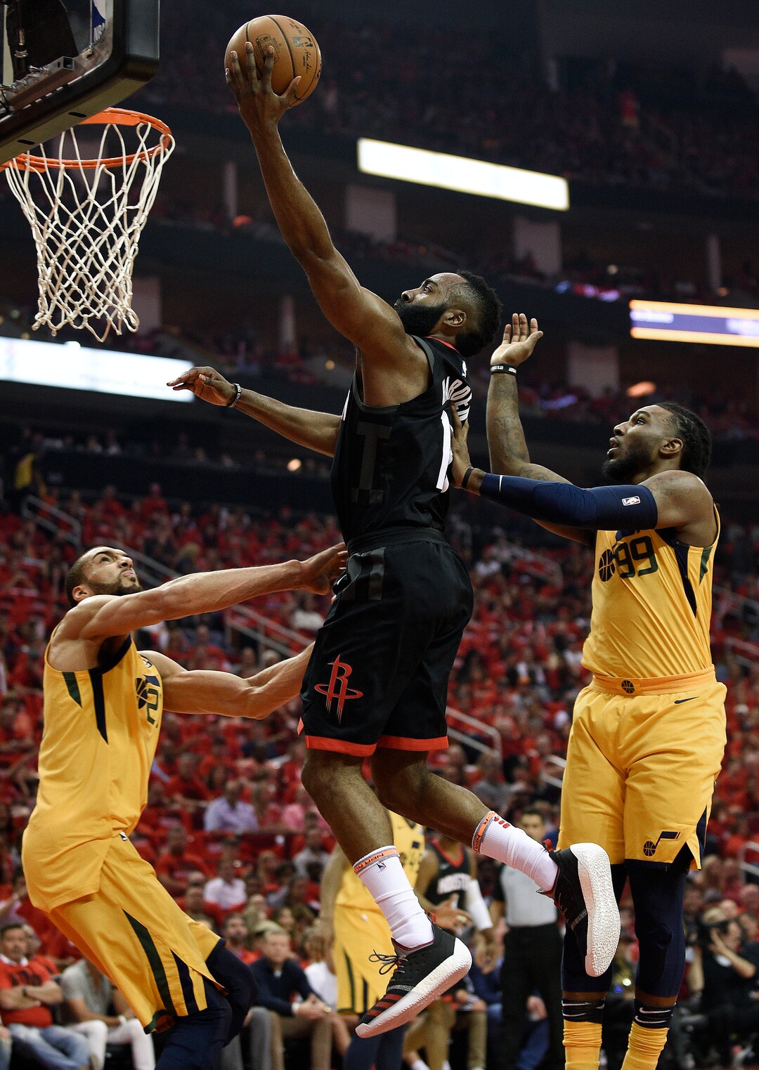 Houston Rockets guard James Harden, center, drives to the basket as Utah Jazz center Rudy Gobert, left, and forward Jae Crowder defend during the first half in Game 1 of an NBA basketball second-round playoff series, Sunday, April 29, 2018, in Houston. (AP Photo/Eric Christian Smith)