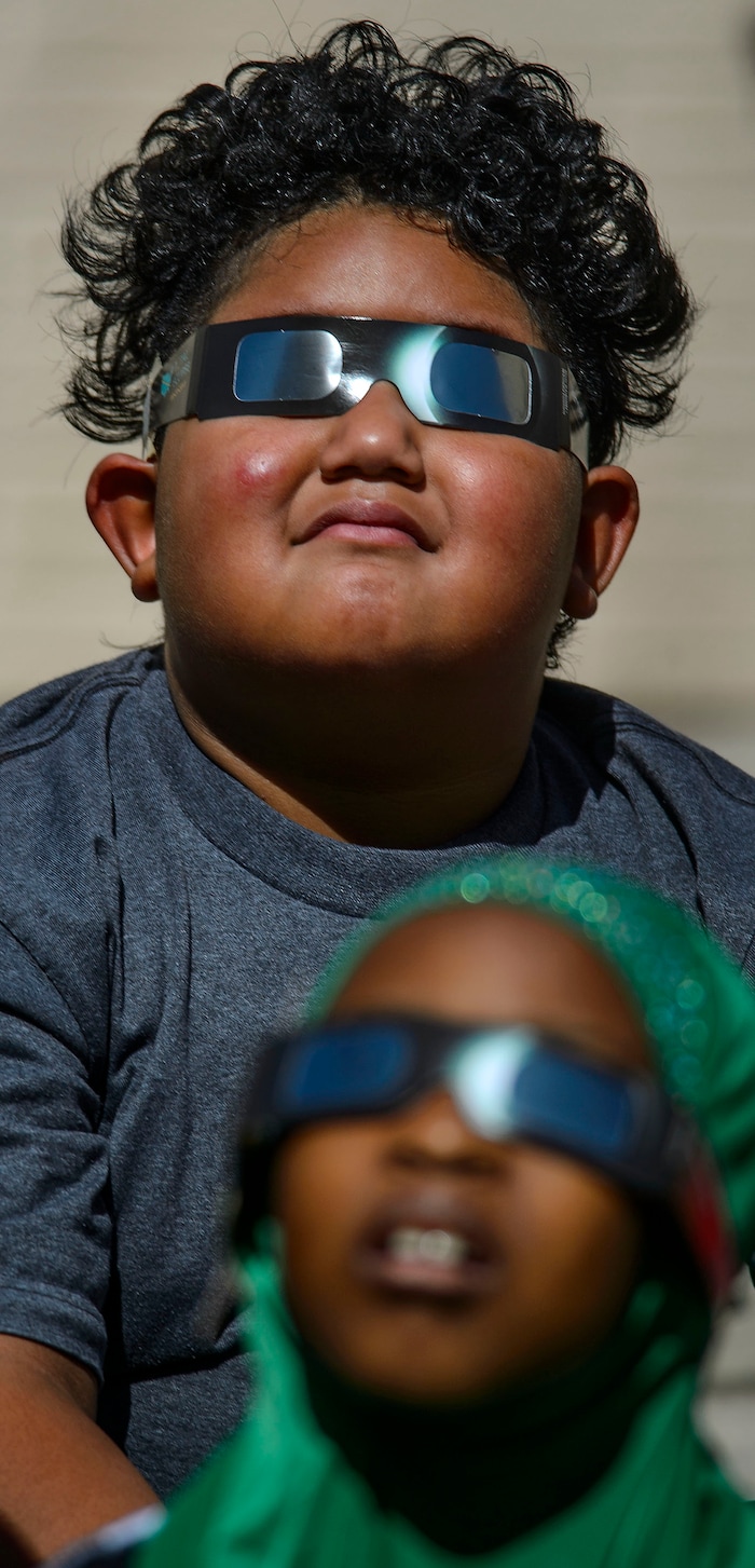 (Steve Griffin  |  The Salt Lake Tribune) Meadowlark Elementary School first-graders Maukakala Taufu'i and Fartun Musa watch The Great Eclipse during the Salt Lake School District's first day of the 2017-2018 school year. STEAM teacher-coordinator Wendi Laurence who formerly worked at NASA has been planning an event around the eclipse. All students had glasses to view the event and many had lunch outside at the Salt Lake City school Monday August 21, 2017.