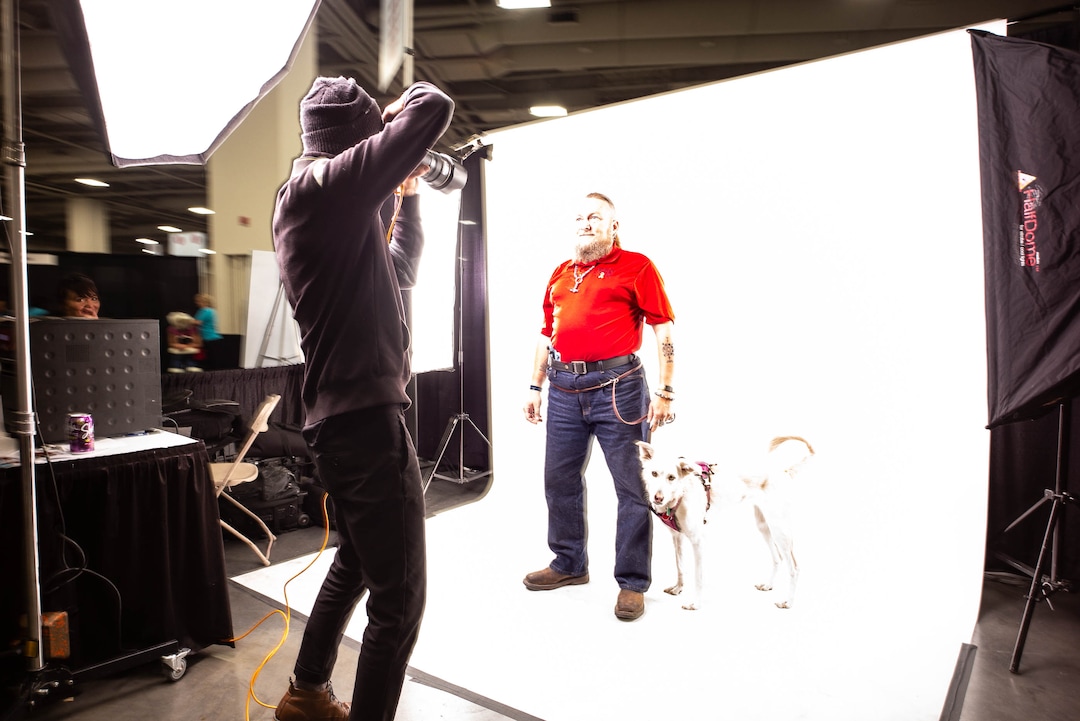 (Trent Nelson  |  The Salt Lake Tribune)Volunteer Dave Brewer photographs Chris Ponton and his dog Minnie at Project Homeless Connect, where community volunteers to provide services for individuals and families experiencing homelessness, at the Salt Palace Convention Center in Salt Lake City on Friday Oct. 25, 2019. Brewer is with Photo Collective Studios.
