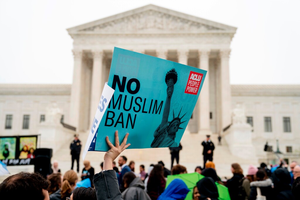(AP Photo/Andrew Harnik, File) In this April 25, 2018, photo, a person holds up a sign that reads "No Muslim Ban" during an anti-Muslim ban rally as the Supreme Court hears arguments about wether President Donald Trump's ban on travelers from several mostly Muslim countries violates immigration law or the Constitution in Washington.